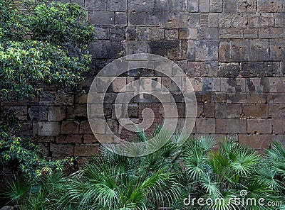 Fragment of ancient stone wall made of different form and size blocks with black stains on it. Stock Photo