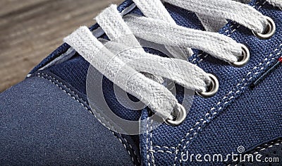 Fragment of a blue sneaker with white drawstring macro Stock Photo