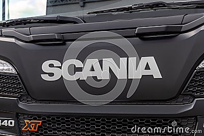 Fragment of the cab of the new Scania heavy truck. Scania logo on the protective grille. A close-up of the front of a Editorial Stock Photo