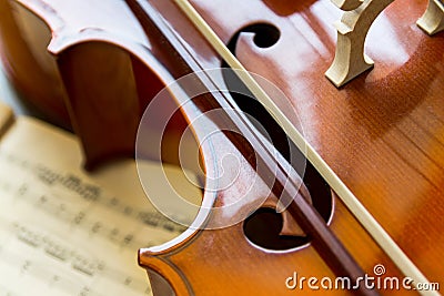 Fragment of a cello on wooden background with music sheets. Rehearsal before the concert. Musical tuition concept Stock Photo