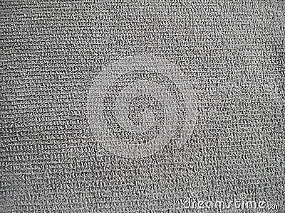 Fragment of a dense thick gray fabric. Fine weaving of threads creates an uneven texture. The surface is rough, but soft to the Stock Photo