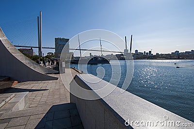 Fragment of the embankment of the city of Vladivostok with elements and the Golden Bridge Editorial Stock Photo