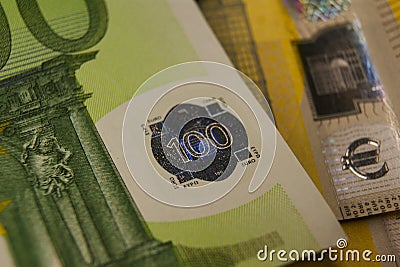 A fragment of a 100 euro banknote with a hologram. Eurozone currency fragment. Stock Photo