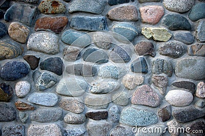 A fragment of a fence of round stones and cement ligaments. Background, texture. Landscape Stock Photo