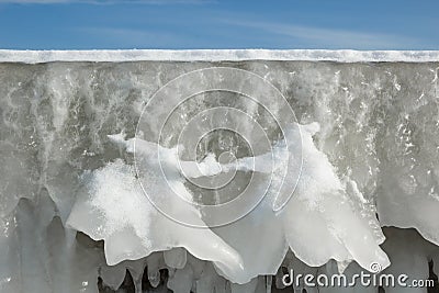 Fragment of a frozen breakwater wall with icicles Stock Photo