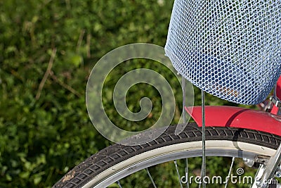 Fragment of a ladies` bicycle in red and white color. Stands in the park on the lawn. Close-up shot Stock Photo