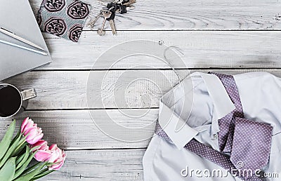 Fragment of a men`s shirt with a tie on a hanger, tulips, coffee Stock Photo
