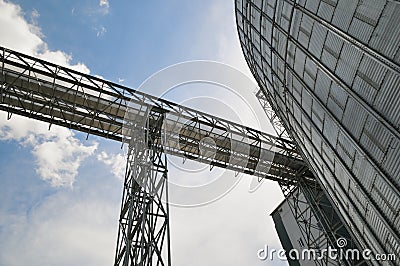 Fragment of metal grain elevator in facility with silos. Stock Photo