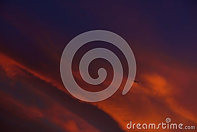 Fragment photo of one airplane going up in dramatic colourful sky background . Airplane in the sky on sunset Stock Photo