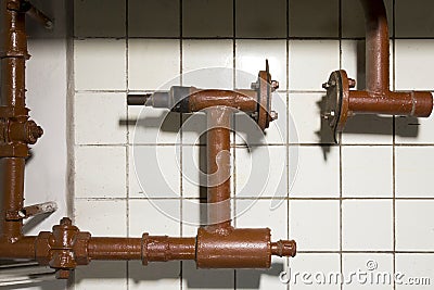 Fragment of a pipeline with cranes and connections on a tile background Stock Photo