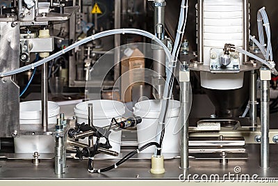 Production line in the food industry, automatic packaging machine for products in plastic buckets Stock Photo