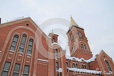 Fragment of a red brick church with windows and gilded roof Stock Photo