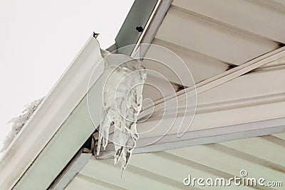 Fragment of roof overhang with icy icicle gutter Stock Photo