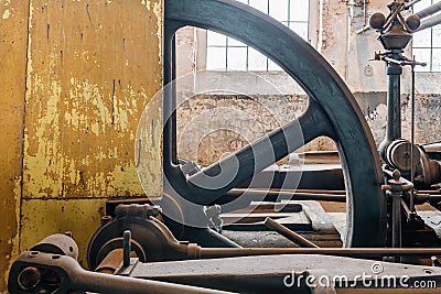 Fragment of steam generator used for steam engines in historical factory from 1903. Huge flywheel and yellow casing of the Stock Photo