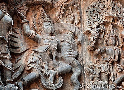 Fragment of stone carved relief with Garuda fighting a myth snake. 12th century South Indian temple. Halebidu, India Stock Photo