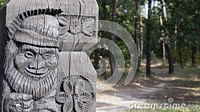 Fragment of a wooden carved gateway with good forest gnomes in a wood Park. Stock Photo