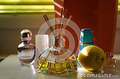 Fragrance diffusor glass with reed sticks between perfume flacons giving natural scent of lemon Stock Photo