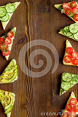 Frame of avocado sandwiches on wooden kitchen table top space for text Stock Photo