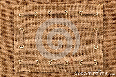 Frame burlap with one lines of rope inserted into gold rings. Top view Stock Photo