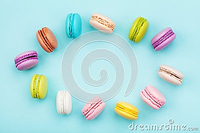Frame from cake macaron or macaroon on mint pastel background from above. Colorful cookies on dessert top view. Stock Photo
