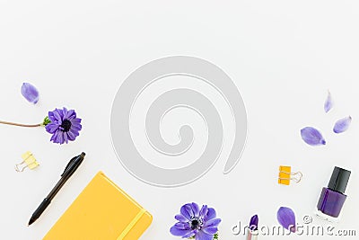 Frame composition with yellow notebook, blue anemones and nail polish on white. Flat lay Stock Photo