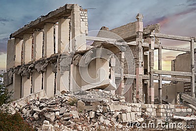 The frame of the destroyed building with a pile of debris of concrete and brick. Close-up. Stock Photo