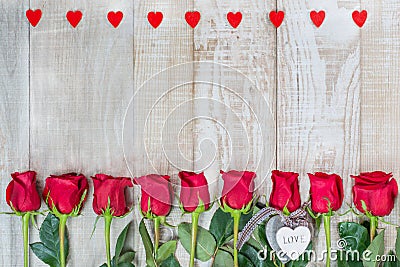 Frame of hearts and red Dutch varietal roses freedom on a light wooden surface. Floral outline with wooden hearts. Idea for Stock Photo