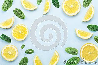 Frame from lemon slices and mint leaves on blue pastel table top view. Ingredients for summer drink and lemonade. Flat lay style. Stock Photo