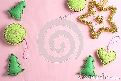 frame made of toys on a pink background. felt ornaments in the form of balls, hearts and fir-trees. Stock Photo