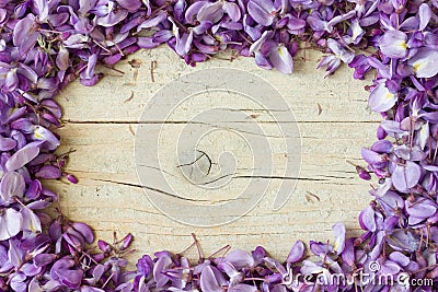 Frame made of violet wisteria flowers on white wooden background Stock Photo