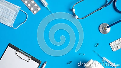 Frame of medical equipment, tools, supplies on blue background. Top view doctor table with medical clipboard, stethoscope, Stock Photo