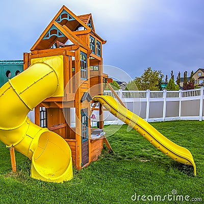 Frame Square Playground at the backyard of a home inside a white wooden fence. Stock Photo