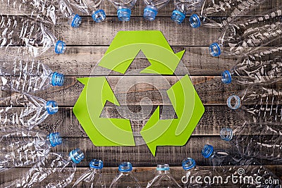 Frame of used plastic bottles with recycling symbol on wooden background. Recycle concept Stock Photo