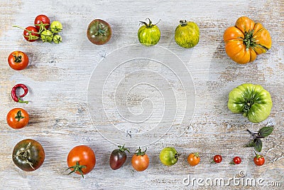 Frame of Various different color organic homegrown tomatoes on old wooden painted background. Background with red Stock Photo