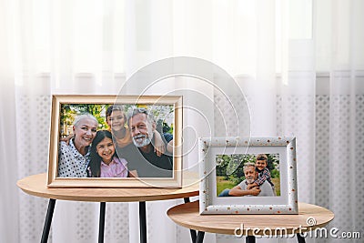 Framed family portraits near window in room Stock Photo