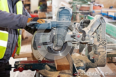 Framing contractor using a circular cut off saw to trim wood studs to length Stock Photo