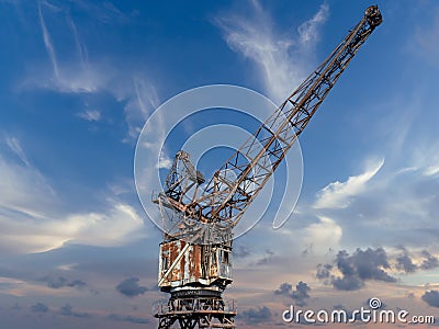 France Caen January 25 2020. Old gantry crane standing at the canal wharf in the harbor used for unloading. Blue sky at sunset Editorial Stock Photo