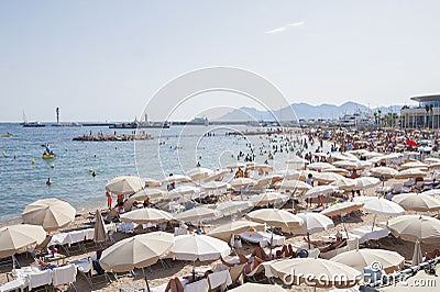 FRANCE, CANNES - AUGUST 6, 2013: People relax on the beach during the high season. Editorial Stock Photo