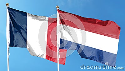 France flag and Netherlands flag on cloudy sky. Stock Photo