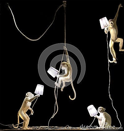 4 monkeys window display. Each white monkey holds a white lamp in his hand. Editorial Stock Photo