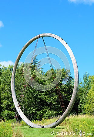 FRANCONIA SCULPTURE PARK, SHAFER, MINNESOTA Wooden circle statue in a blue sky with clouds and green field Editorial Stock Photo