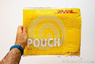 Man holding yellow DHL Express Editorial Stock Photo