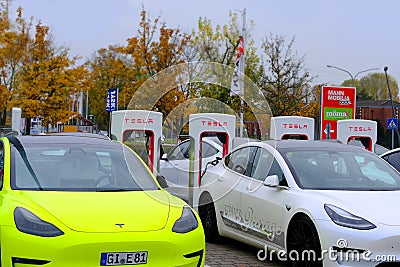 Frankfurt, Germany, October 2021: many Tesla light electric cars replenish battery at charging station, alternative energy Editorial Stock Photo