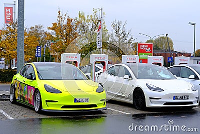 Frankfurt, Germany, October 2021: many Tesla light electric cars replenish battery at charging station, alternative energy Editorial Stock Photo