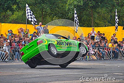 FRANKFURT AM MAIN, GERMANY - SEPT 2022: green BMW 325i E36 car rides sideways on two wheels, at an auto show, Monster Truck auto Editorial Stock Photo
