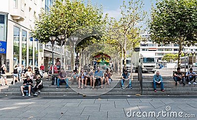 Frankfurt am Main, Hesse Germany - Tourists and locals sitting at the stairs, eating ice cream and drinking soft Editorial Stock Photo