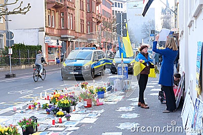 Frankfurt - March 2022: people support Ukraine, flowers lie on ground, mourning candles burning for dead, an anti-war rally near Editorial Stock Photo