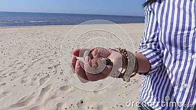 Frau ` s Hand mit Steinen auf Strand nahe Meer Frau ` s Hand mit Steinen auf Strand nahe Meer
