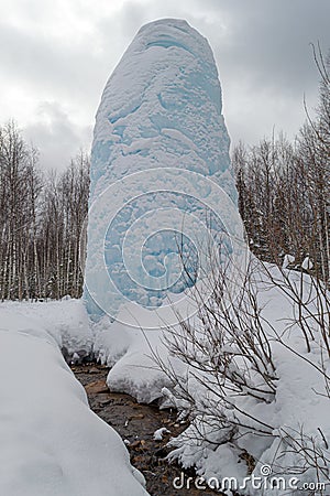 Freaks of nature. Huge icicle formed around a source of artesian Stock Photo