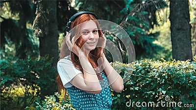 Freckled red-haired teenager listen music in big headphones Stock Photo